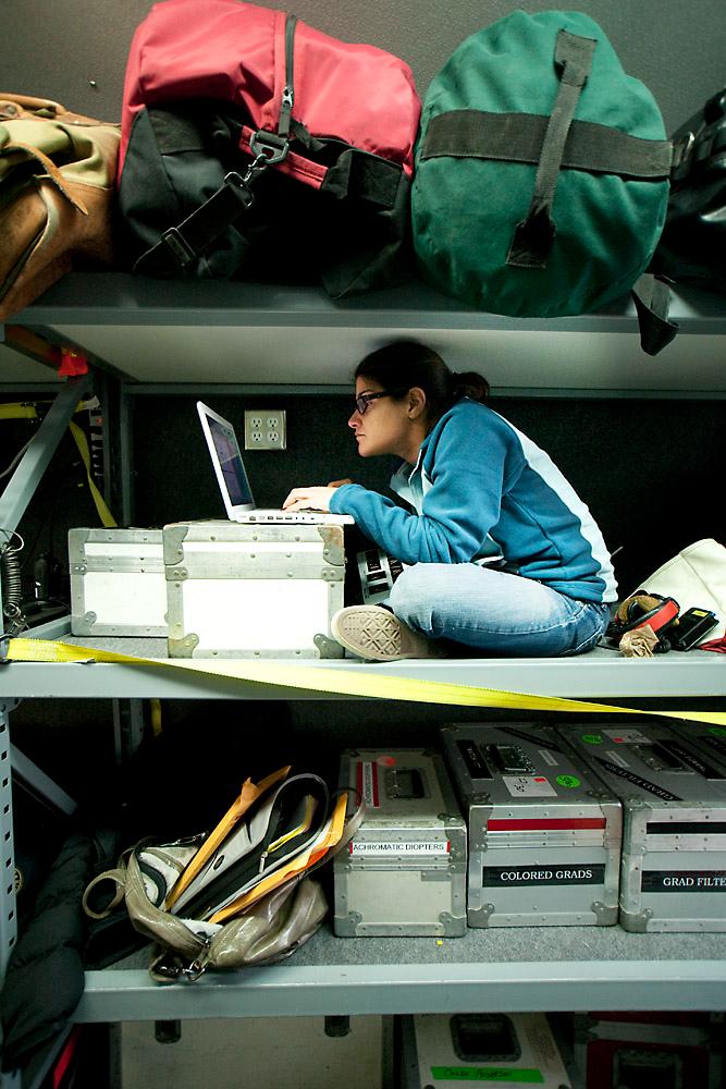 Amy Cohn working on a laptop among production equipment